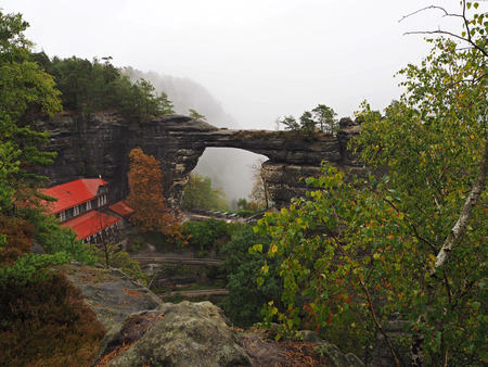 Pravcicka brana  - biggest natural sandstone gate in europe in foggy autumn after rainの写真素材
