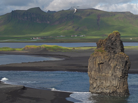 magic iceland landscape with black lava sand and green eroded hillsの写真素材