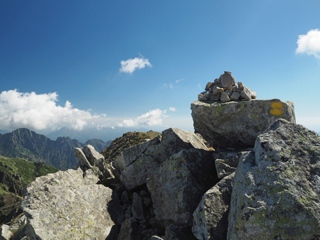 mountain trek scenery cairn yellow marked path, stone pileの写真素材