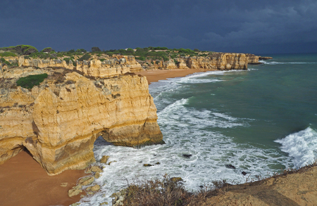 Blue sea shore with sandstone cliffs and dark blue skyの写真素材