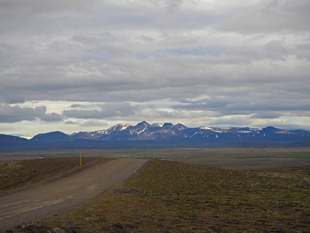 dirty mountain road trough deserted landscape to the colourfull rhyoliet Kerlingarfjöll volcanic mountains in icelandの写真素材