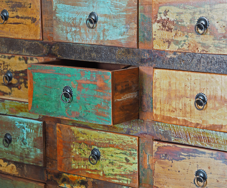 pulled drawer on old wooden colorful dresser with iron hitchの写真素材