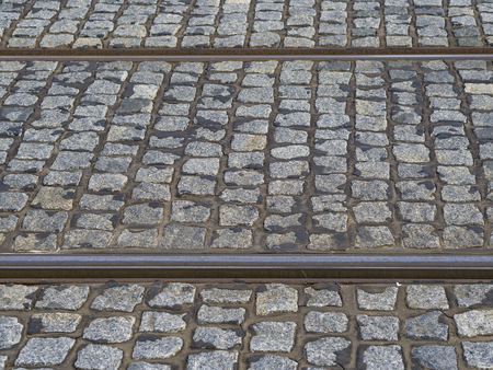 rusty tram rail line track with gray cobble stone in prague pavementの写真素材