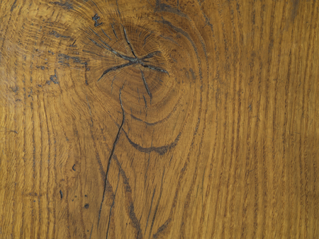 orange hardwood board table with knot hole and annual rings natural wooden backgroundの写真素材