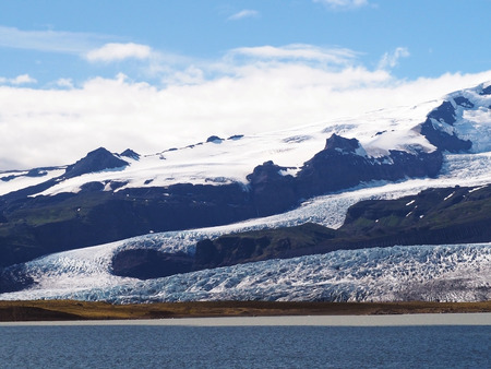 iceberg glacier tongue near Jokulsarlon lagoon in south eastern Iceland blue sky clouds background