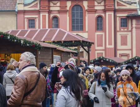Czech republic, Prague, old town, December 2, 2017: crowdy decorated christmas market stands on prague castle forecourt yard with large group of tourist shopping sightseeing and taking pictureのeditorial素材