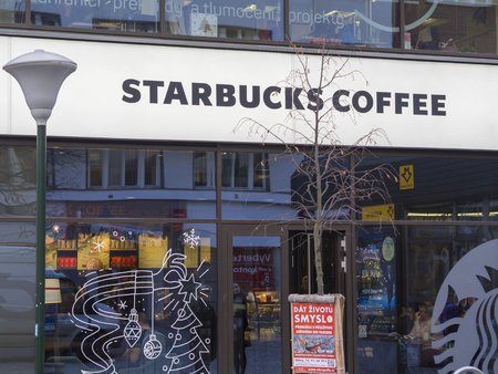 Czech republic, Prague, Karlin, November 27, 2017: entrance to the starbucks coffee in krizikova street shop window with christmas decoration street lamp and bare treeのeditorial素材