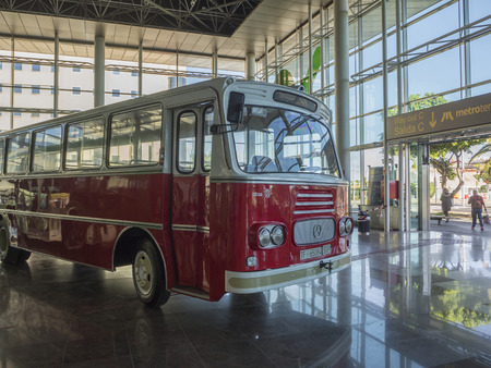 Spain, Canary islands, Tenerife, Santa Cruz de Tenerife, December 27, 2017: shiny red bus vintage veteran car mercedes placed in front of entrance to bus station hallのeditorial素材