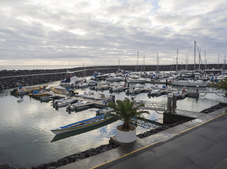 Portugal, VILA FRANCA DO CAMPO, Sao Miguel, Azores, December 20, 2018: Colorful fishermen boats and Yachts in marina of Vila Franca do Campo town, early morning cloudy skyのeditorial素材