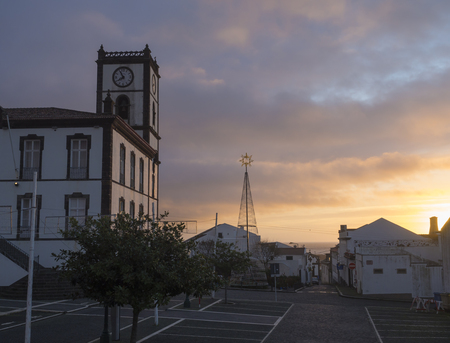 Portugal, VILA FRANCA DO CAMPO, Sao Miguel, Azores, December 20, 2018: Building of Town Hall with clock tower in colonial style and christmas decoration at square in the center of Vila Franca do Campo town, located on Sao Miguel island, colorful sunset skのeditorial素材