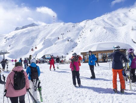 KAPRUN, AUSTRIA, March 12, 2019: Skiers are getting out from Cable car ski lift at Alpin center on the top of the glacier on Kitzsteinhorn and make preparations to go down into the valley. Beautiful blue sky sunny winter day with white snow slopes and pisのeditorial素材