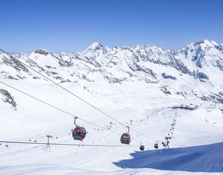 Stubai Glacier, AUSTRIA, May 2, 2019: Snow covered slopes with free rides and pistes and red Cable...