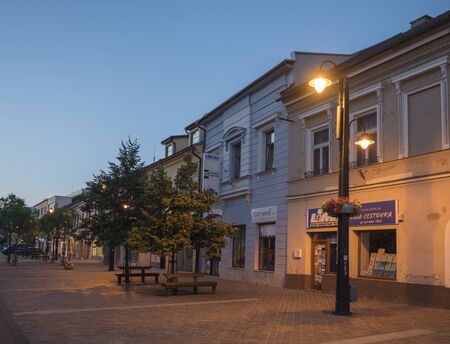 LIPTOVSKY MIKULAS, LIPTOV, SLOVAKIA, July 4, 2019: Pedestrian zone and buildings in the city center of Liptovsky Mikulas town with street lights and walking people. Summer evening, blue hour.のeditorial素材