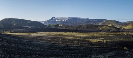 Panoramic sunrise view on Myrdalsjokull glacier. from Botnar campsite at Iceland on Laugavegur hiking trail, green valley in volcanic landscape with Early morning pink lightの写真素材