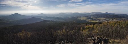Luzicke hory wide panorama, panoramic view from Hochwald Hvozd one of the most attractive view-points of the Lusatian Mountains with autumn colored deciduous and coniferous tree forest and green hills, golden hour light.の写真素材