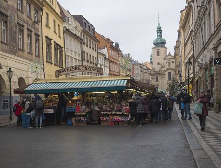 Prague, Czech Republic, December 12, 2019: Tourist people shopping at traditional christmas Market, Havelska trznice street with stalls selling gifts, souvenirs, christmas decorations,toys and fruits.のeditorial素材