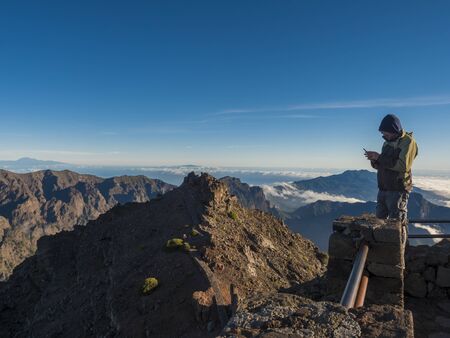 Roque De Los Muchachos, La Palma, Canary Islands, Spain, December 20, 2019: Man tourist standing at view point Mirador Roque De Los Muchachos with volcanic crater Caldera de Taburiente Natoional Parkのeditorial素材