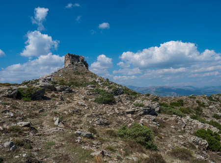 View of limestone tower Perda Liana, impressive rock formation on green forest hill, sardinian table mountain. National Park of Barbagia, Central Sardinia, Italy, summer day.の写真素材