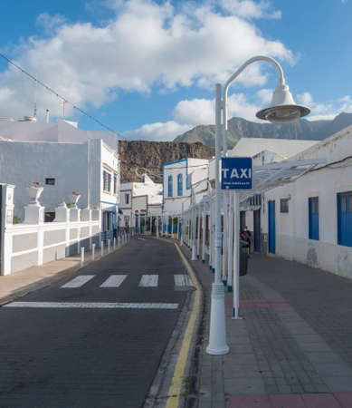 Puerto de las Nieves, Agaete, Gran Canaria, Canary Islands, Spain December 17, 2020: Main street promenade with traditional blue white houses and mountains at Puerto de las Nieves, fishing villageのeditorial素材