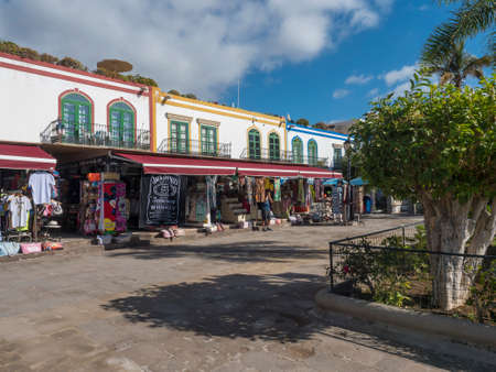 Puerto de Mogan, Gran Canaria, Canary Islands, Spain December 18, 2020: Traditional colorful houses at pedestrian street with souvenir and clothes shops at port Puerto de Mogan, popular tourist resortのeditorial素材