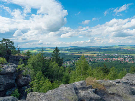 Tempelwand sandstone viewpoint next to hill Topfer near Oybin with view of Zittau town at Poland...