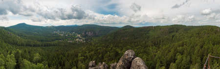 Panoramic view from sandstone rock viewpoint Monchskanzeland on spruce tree forest, village Oybin and Zittauer Gebirge mountains nature park, summer landscape, Germanyの写真素材
