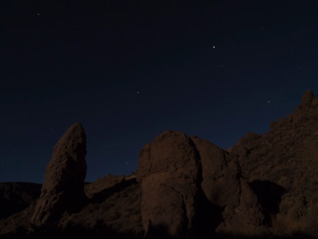 Long exposure night shot of Roques de Garcia with Roque Cinchado volcanic rock formation at El Teide national park, night winter sky with stars on dark blue. Tenerife Canary islands, Spain.の写真素材