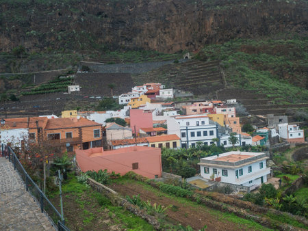 View of old village Agulo with colorful traditional houses, terraced fields and mountain in green valley at north coast. Cloudy winter day. La Gomera, Canary Islands, Spainの写真素材