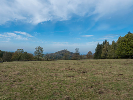 Meadow with autumn colorful forest, trees and hills, blue sky. Landscape in Luzicke hory Lusatian Mountains.の写真素材