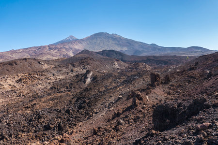 Winter view on colorful volcano Pico del Teide with snow spots from hiking trail Samara. Mountains and lava fields against blue sky. El Teide National Park, Tenerife, Canary Islands, Spainの写真素材