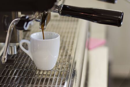 coffee flows from a coffee machine into a cup1の写真素材