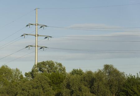 Pillar and power lines against a cloudy skyの写真素材