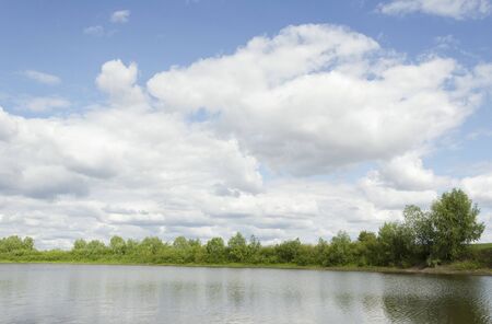 pond on a background of blue skyの写真素材