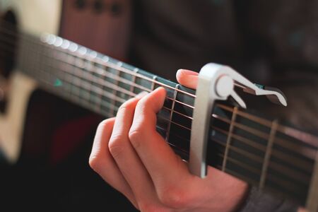 Young man playing on acoustic guitar