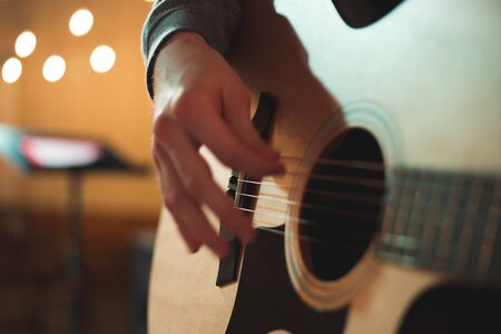Young man playing on acoustic guitar