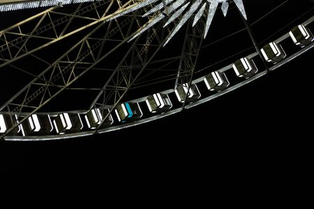 Beautiful ferris wheel with white cabs at nightの写真素材