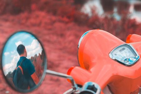 Reflection of a man in the side mirror of a motorbikeの写真素材