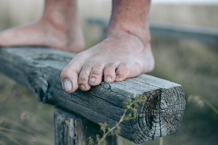 Man barefoot on the log in daylightの写真素材