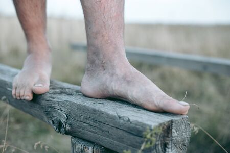 Man barefoot on the log in daylightの写真素材