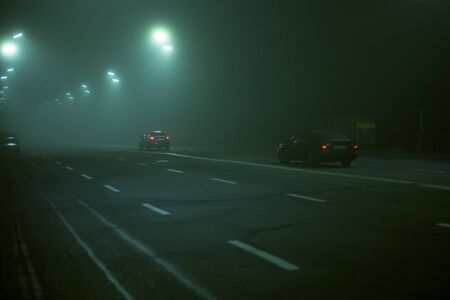 Highway road at night in the fog in the cityの写真素材
