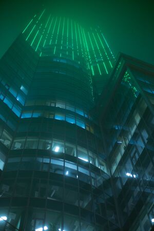Tall office building at night in foggyの写真素材