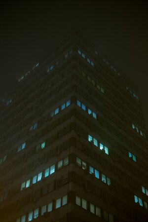 Tall office building at night in foggyの写真素材