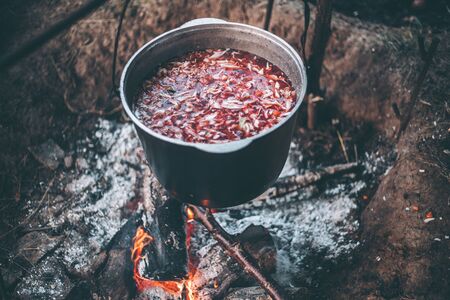 Cauldron with soup on a campfire in a hike