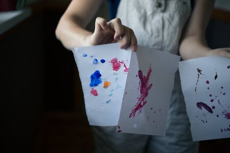 Hand holds abstract drawings on paper.の写真素材