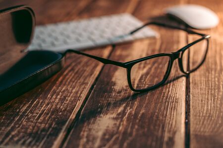 Glasses for sight and vision correction and protection from computer with ptotection case on the wooden tableの写真素材