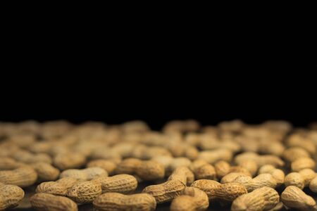 Ripe unroasted peanuts in husk and background