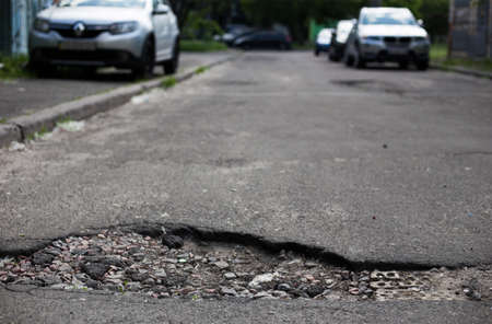 Broken asphalt and cracks on the road surfaceの写真素材