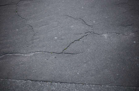Broken asphalt and cracks on the road surfaceの写真素材