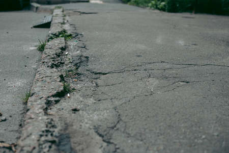 Broken asphalt and cracks on the road surface