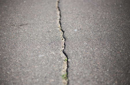 Broken asphalt and cracks on the road surfaceの写真素材